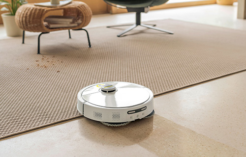 Saug-Wisch-Roboter hebt sein feuchtes Wischtuch über einem Teppich an